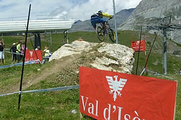 a picture of a mountain biker going over a large rock jump