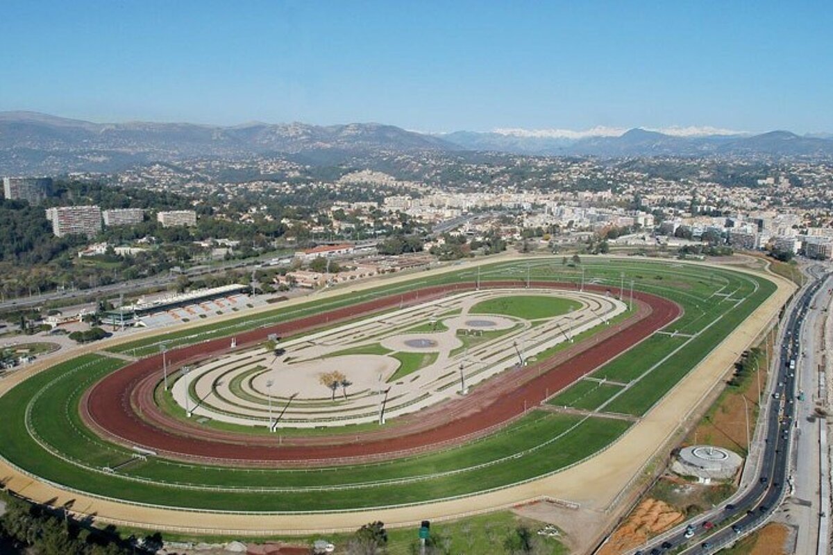 An aerial view of a race track with mountains in the background