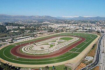 An aerial view of a race track with mountains in the background