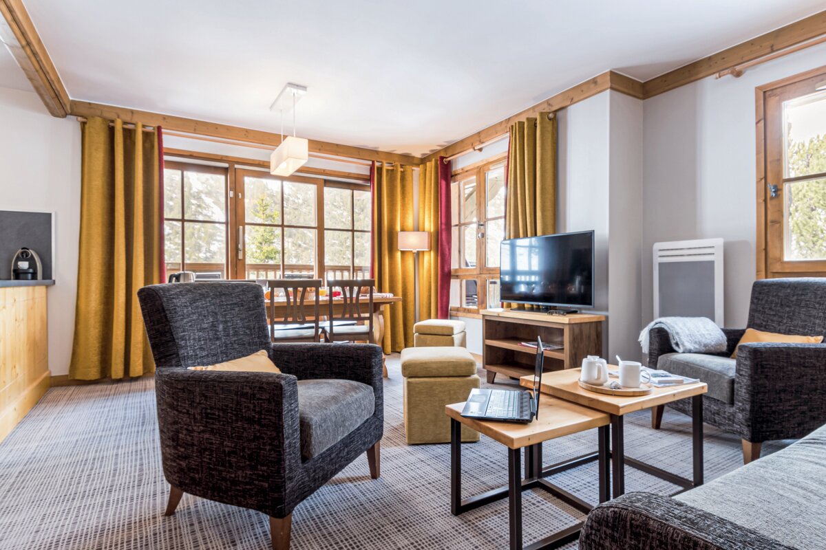 A living room with two chairs and a flat screen tv