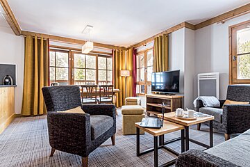 A living room with two chairs and a flat screen tv