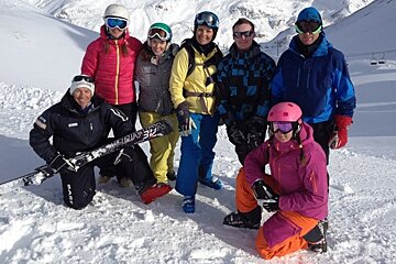 a group of skiers taking a break on the piste