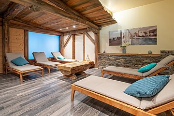 A room with lounge chairs and a picture of a pool on the wall