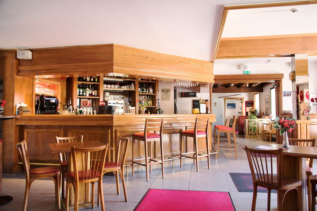 A restaurant with tables and chairs and a bar