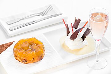 A plate of desserts next to a glass of wine