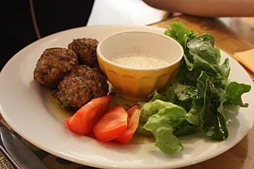 a plate of meatballs with salad