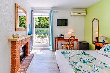 A bedroom with a brick fireplace and a flat screen tv