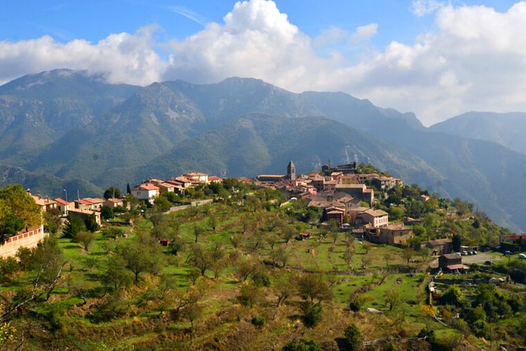a view of a village and mountains in alpes-maritime