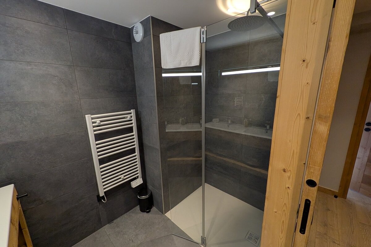 A bathroom with a walk in shower and a towel rack