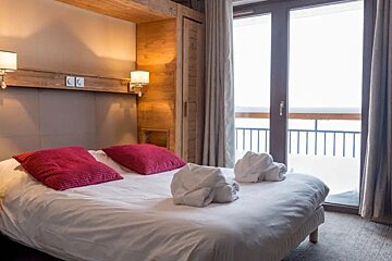 A hotel room with a large bed and a balcony