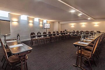 A conference room with tables and chairs set up for a meeting