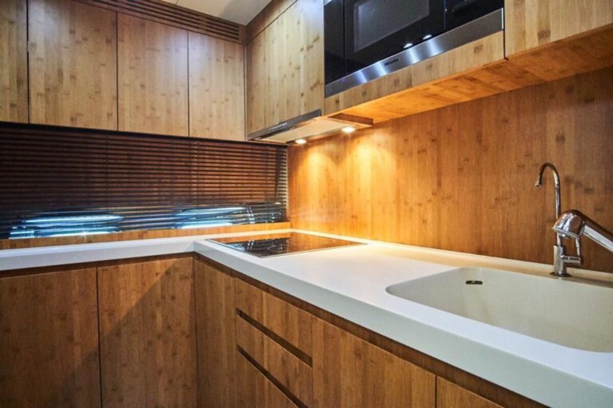 A kitchen with wooden cabinets and white counter tops