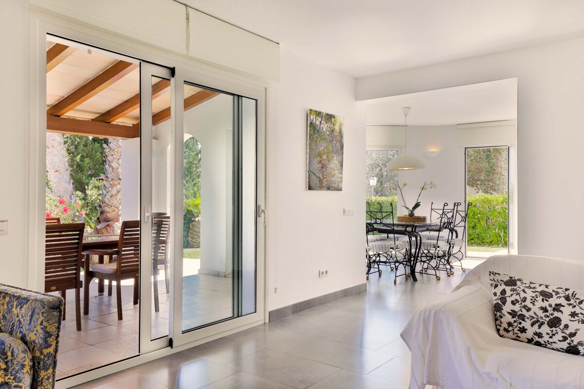 A living room with a sliding glass door leading to a dining room
