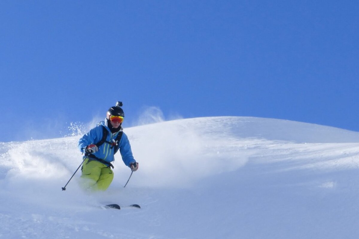 a skier in yellow pants in fresh snow