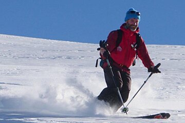 a man skiing in a red jacket