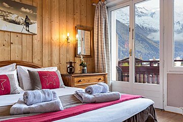 A bedroom with a large window and a picture of a skier on the wall