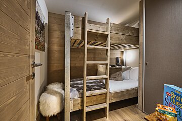 A bunk bed in a room with a book called ligretto on the floor