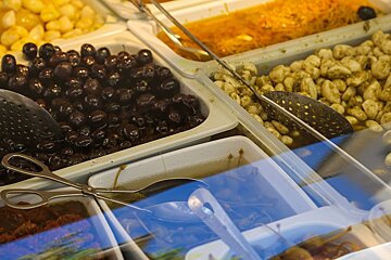 A display case filled with different types of food including olives
