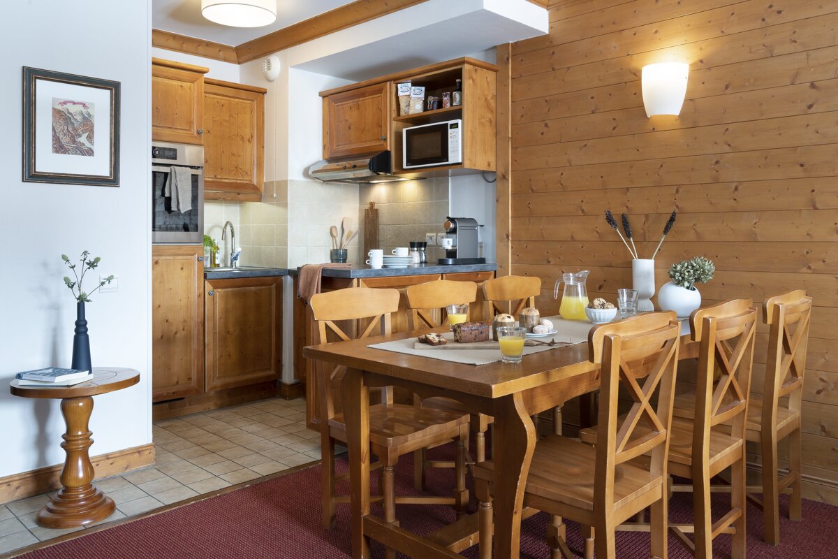 A kitchen with a table and chairs and a microwave