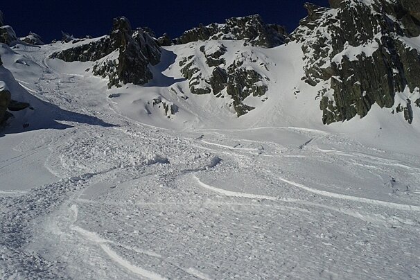 picture of fresh snow with some rocks and blue skies in the back ground