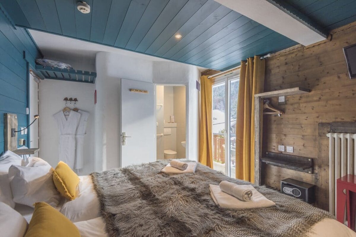 A hotel room with a bed and a safe