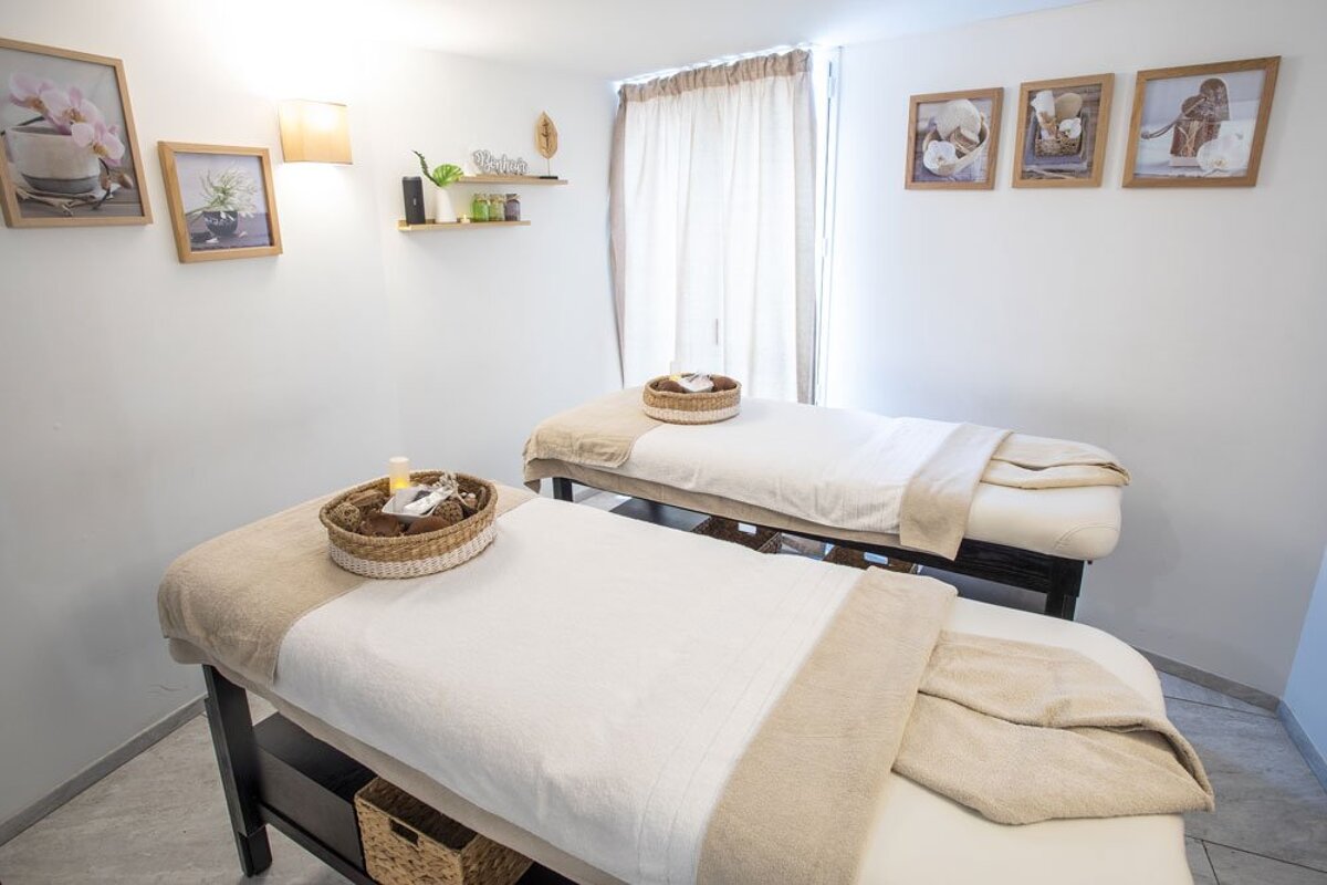 Two massage tables in a room with pictures on the wall