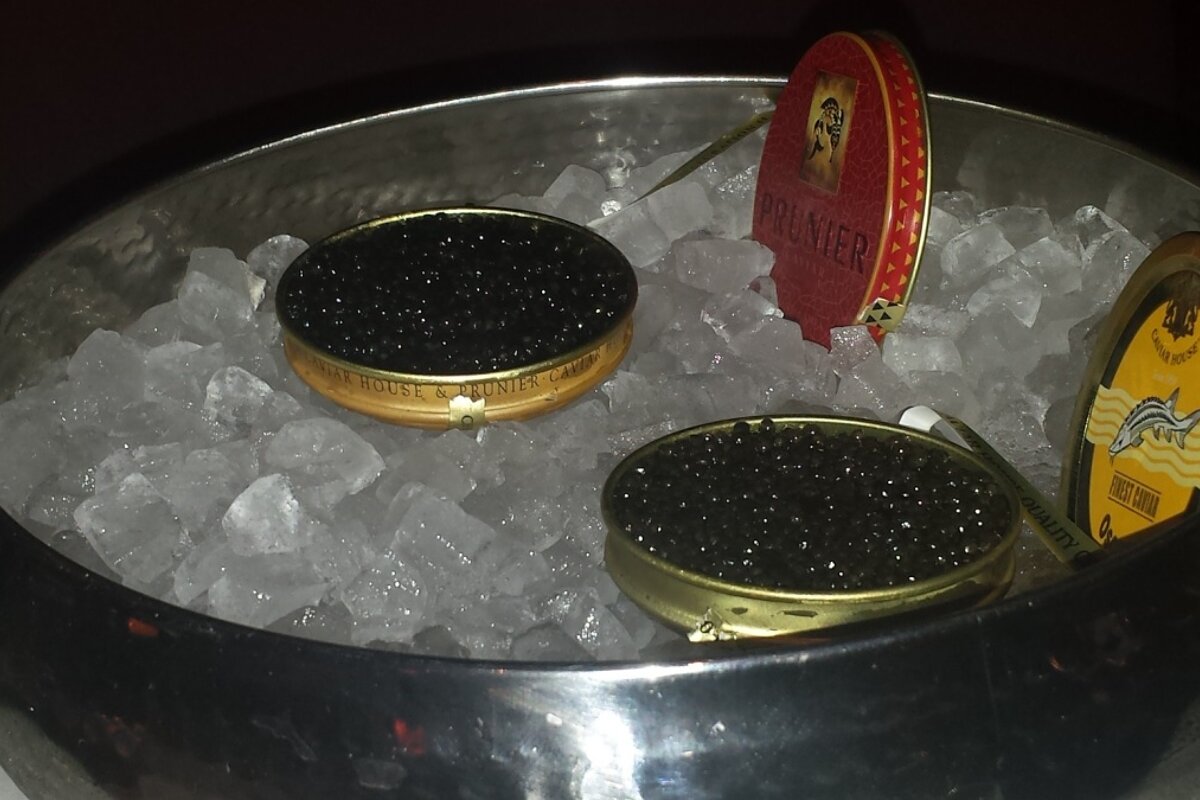 two pots of caviar in an ice bucket