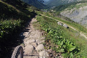 a bike going over some rocks on a trail