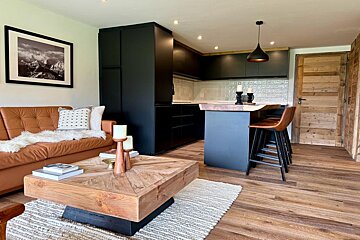 A living room with a brown couch and a wooden coffee table