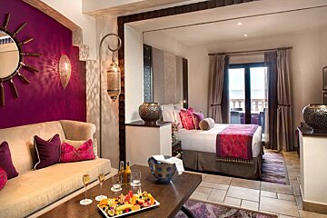 A hotel room with a couch and a bed