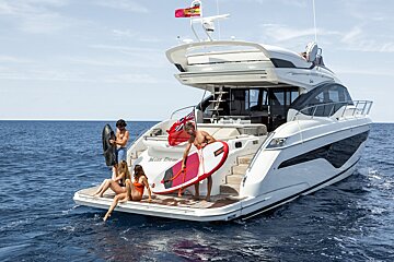 A group of people on a yacht with the name miss dew on the back