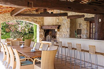 A patio area with a table and chairs and a fireplace
