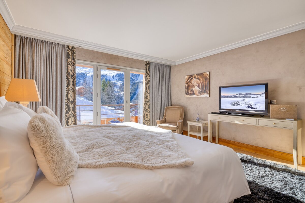 A bedroom with a large bed and a flat screen tv