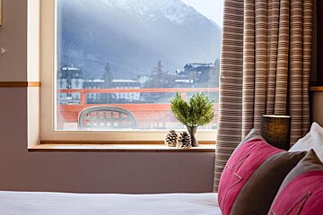 A bedroom with a view of mountains and a balcony
