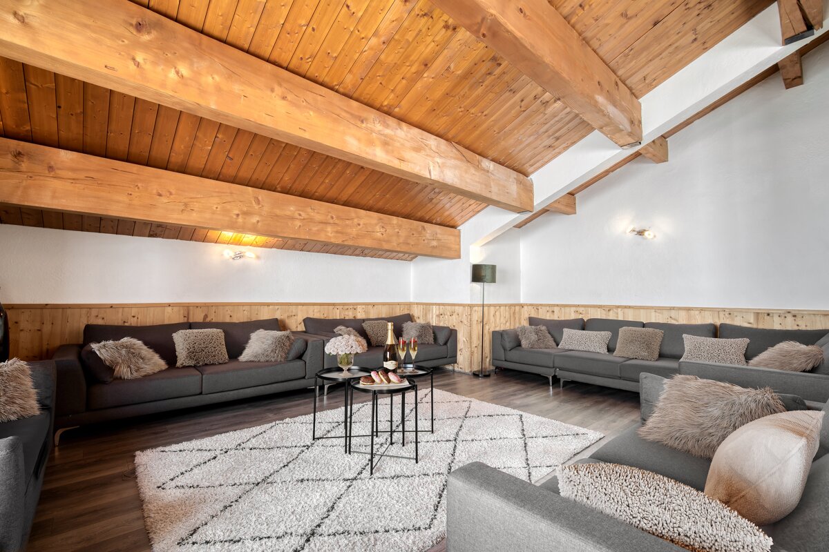 A living room filled with furniture and a wooden ceiling