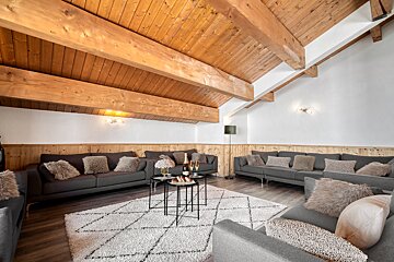 A living room filled with furniture and a wooden ceiling