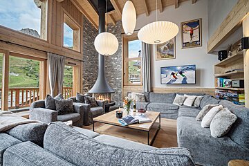 A living room with a large sectional couch and chairs