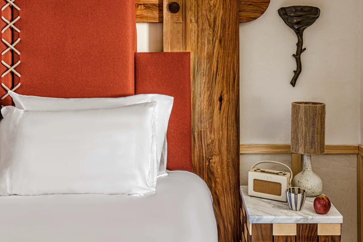 A bed with white sheets and a wooden headboard