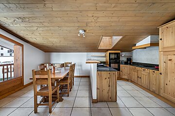 A kitchen with wooden cabinets and a dining table
