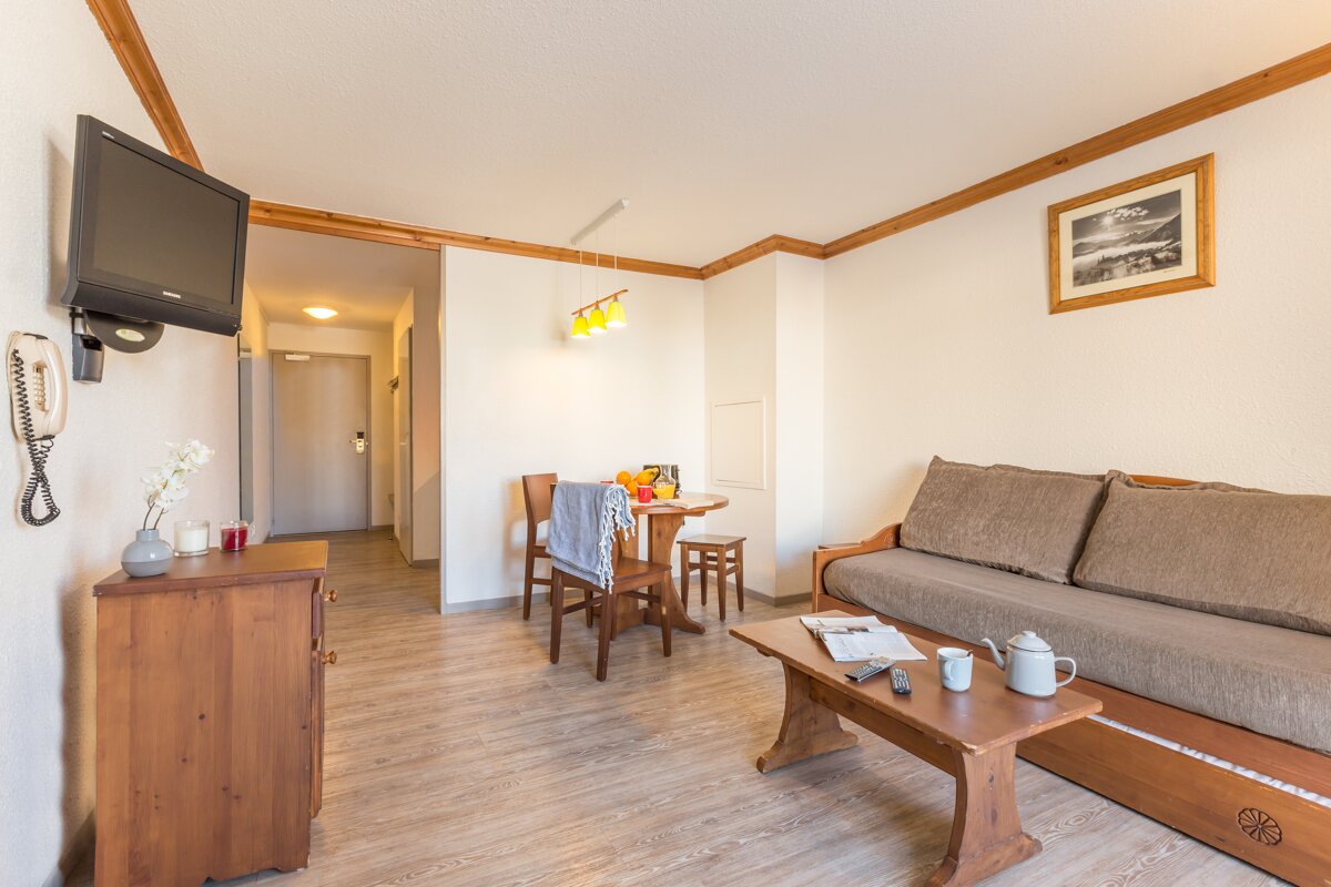 A living room with a couch a table and a television