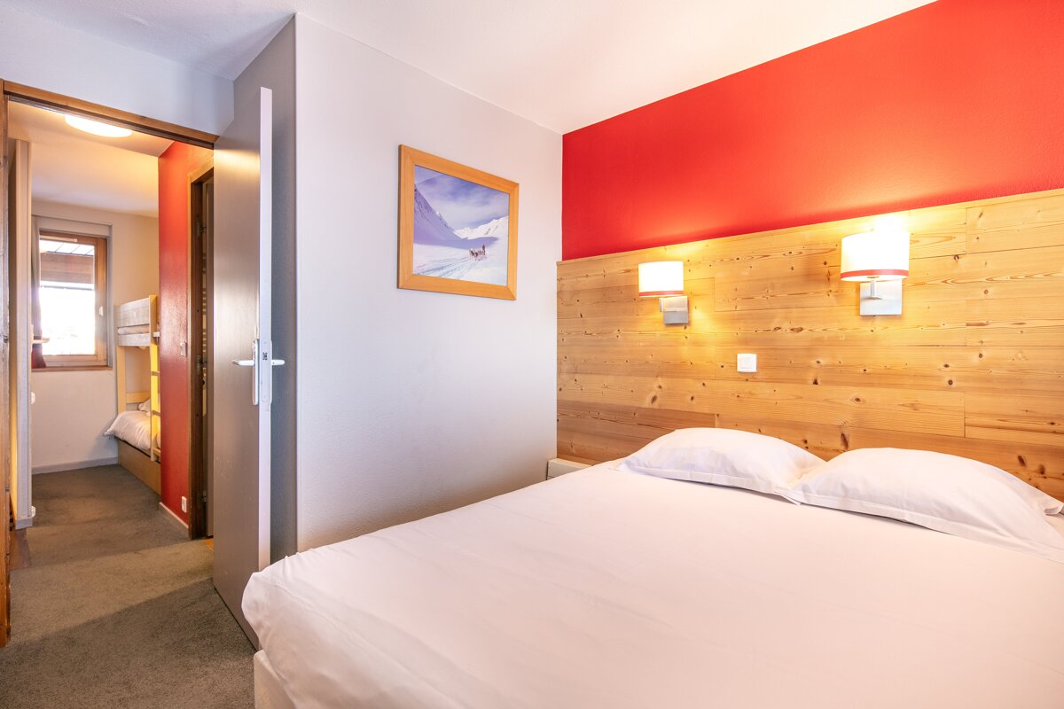 A bedroom with a bed and a picture on the wall