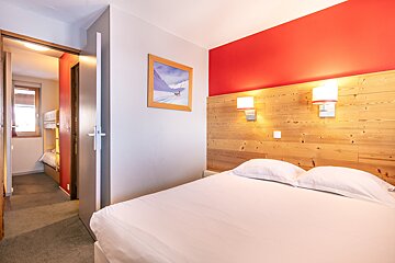 A bedroom with a bed and a picture on the wall