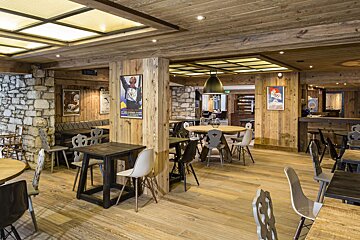 A restaurant with wooden tables and chairs and a sign that says coca cola