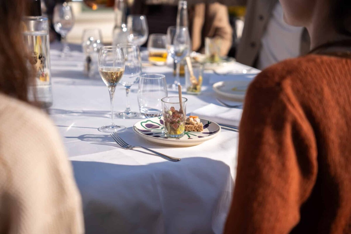 A woman sits at a table with a plate of food on it