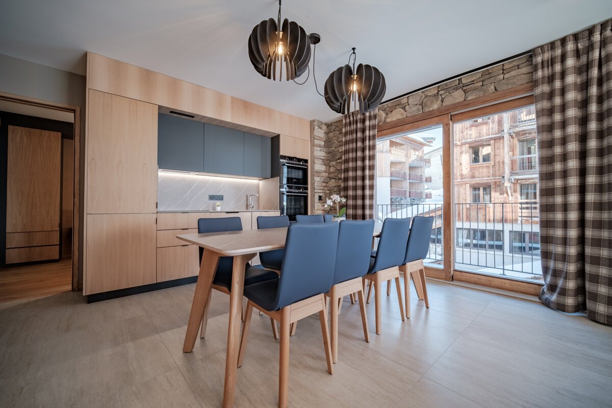 A kitchen with a table and chairs and a sliding glass door