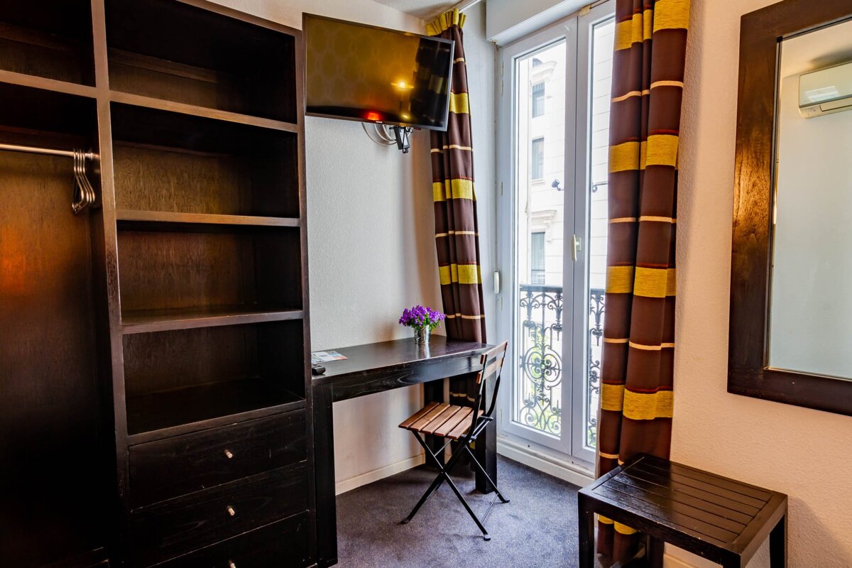 A room with a desk a chair and a television