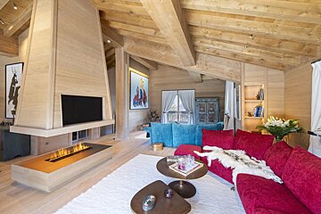 A living room with a red couch and a fireplace