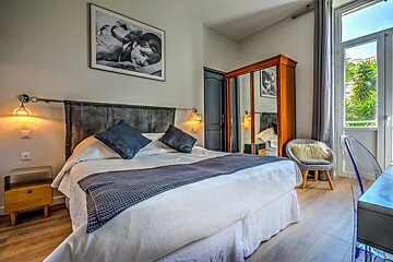 A bedroom with a bed and a picture on the wall