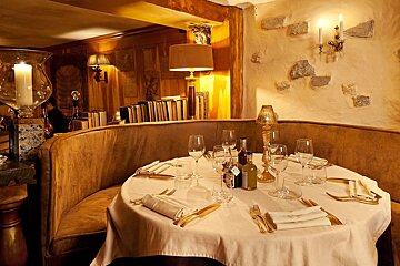 A bottle of olive oil sits on a table in a restaurant