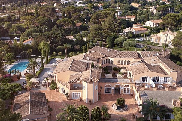 An aerial view of a large house surrounded by trees